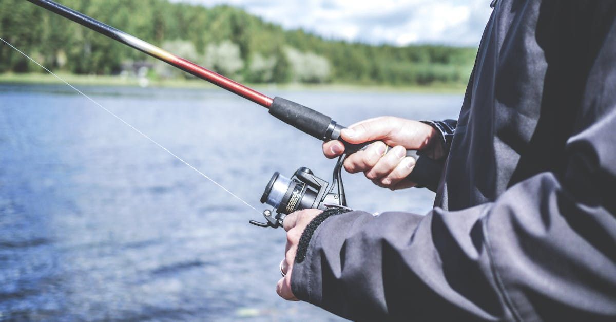 A man is fishing on a lake with a fishing rod.