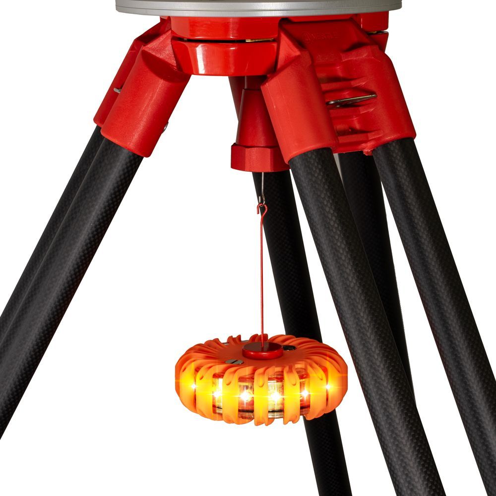 An orange emergency light with a red hook attached to it