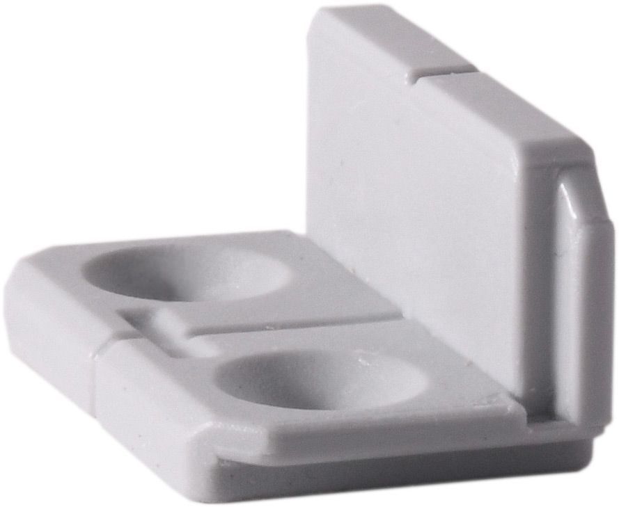 A white plastic block with two holes in it on a white background.