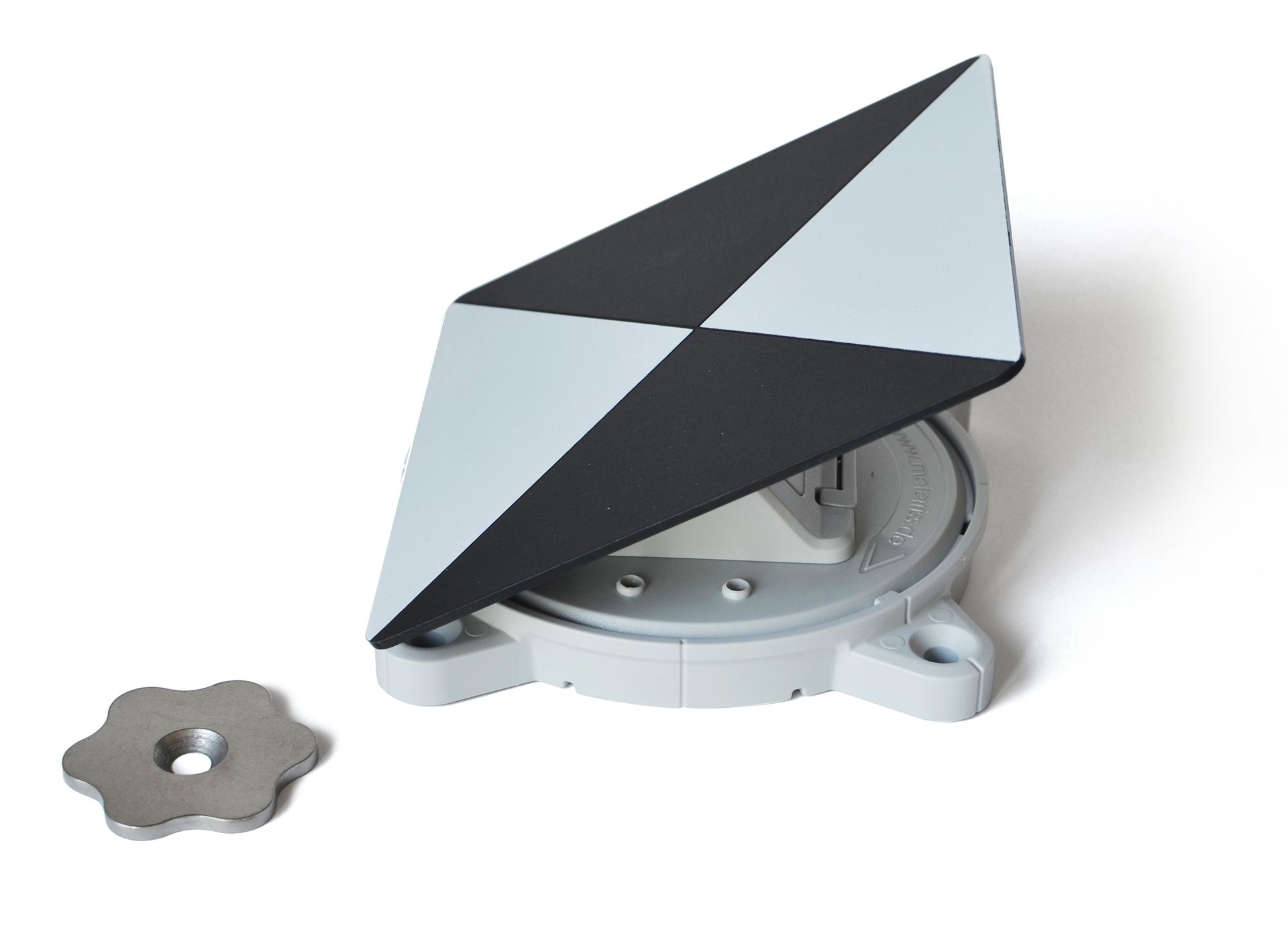 A black and white triangle shaped object is sitting on a white surface.