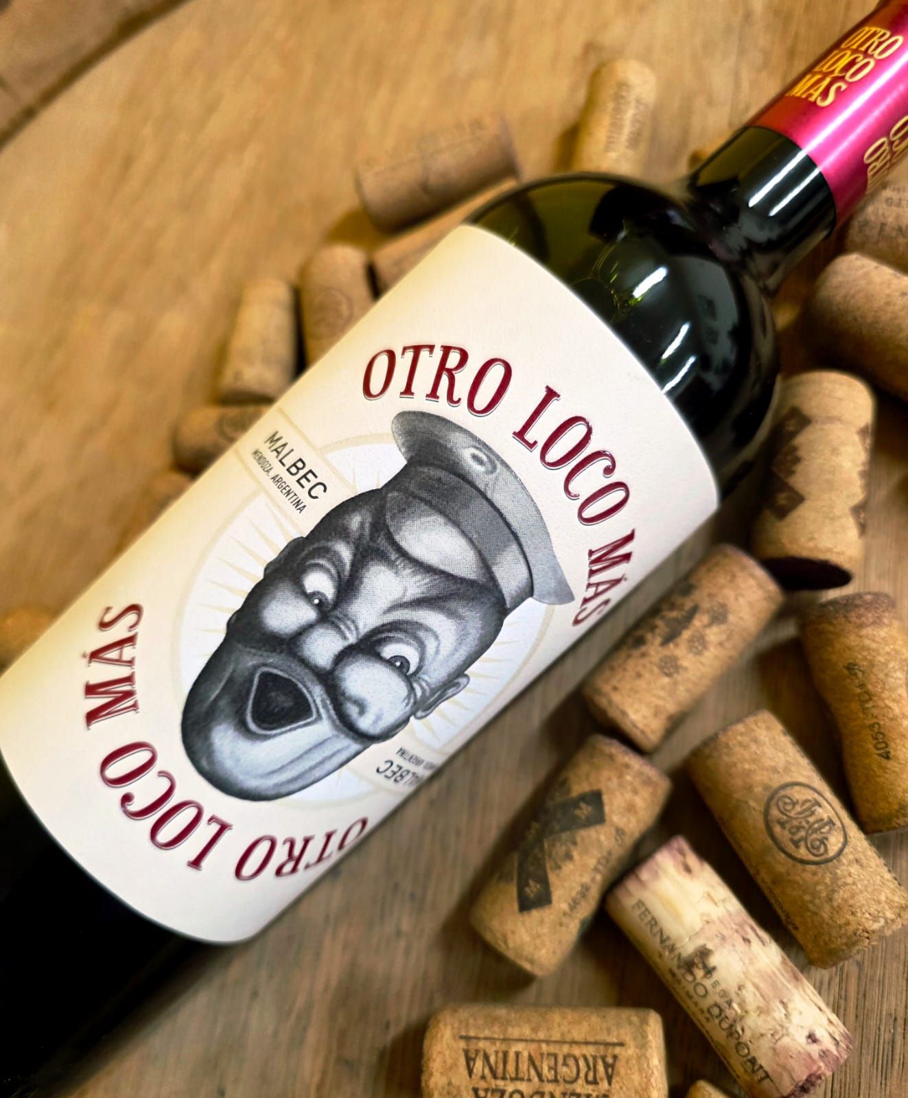 Una botella de vino Otro Loco Más Malbec, con una cara de dibujos animados en la etiqueta