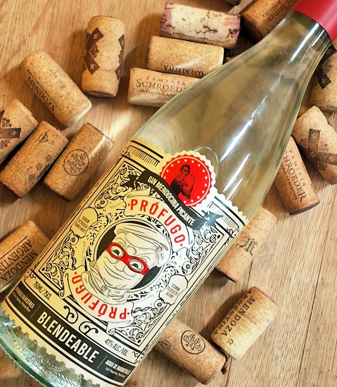 Una botella de vino Prófugo con un personaje ilustrado con máscara roja en la etiqueta, rodeada de corchos
