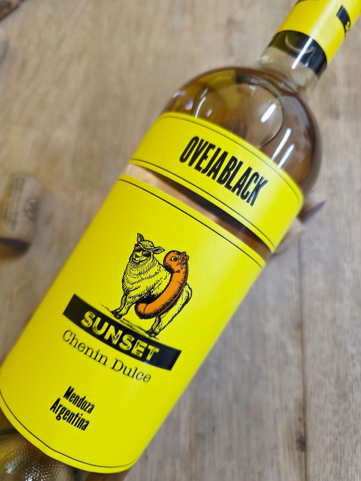 Una botella de vino Oveja Black Sunset Chenin Dulce con una etiqueta amarilla