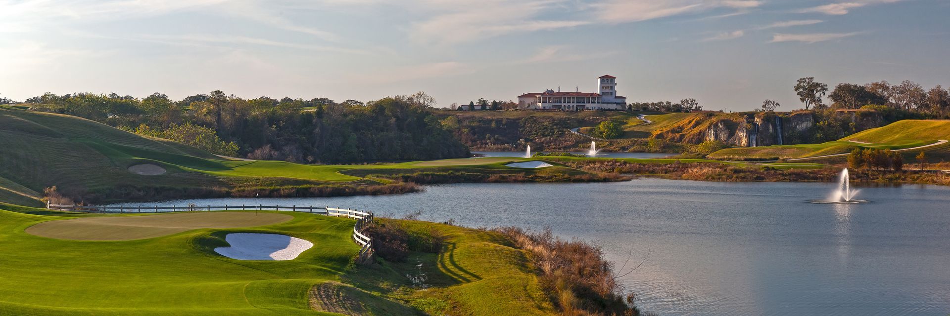 A golf course with a lake in the background