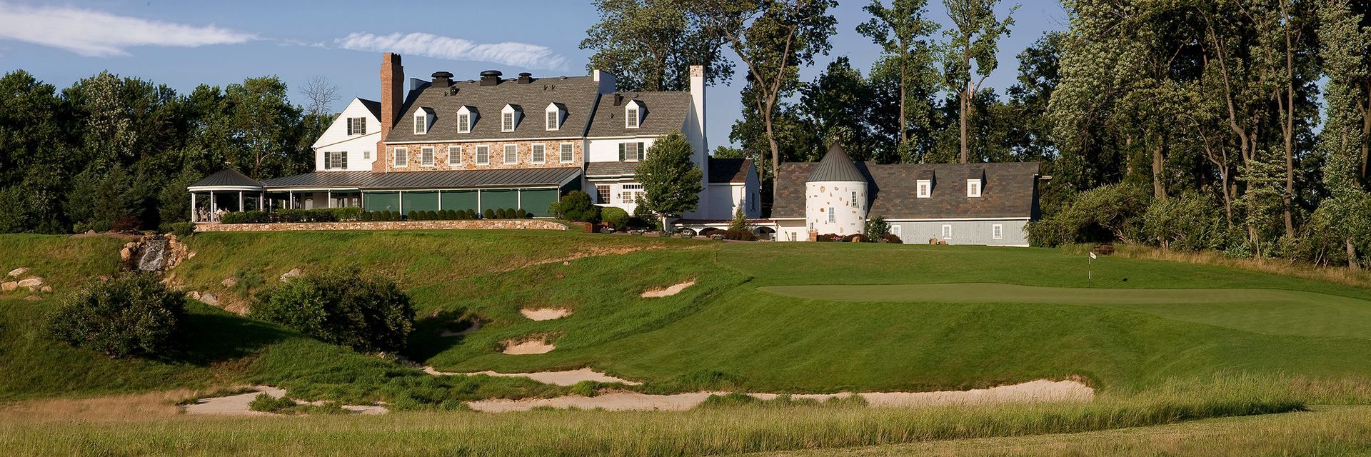 A large house sits in the middle of a grassy field