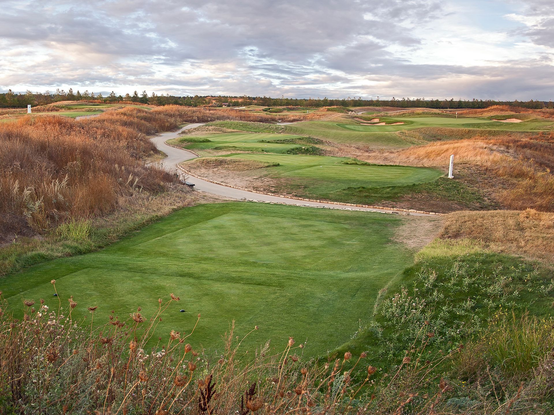 A view of a golf course with a river running through it.