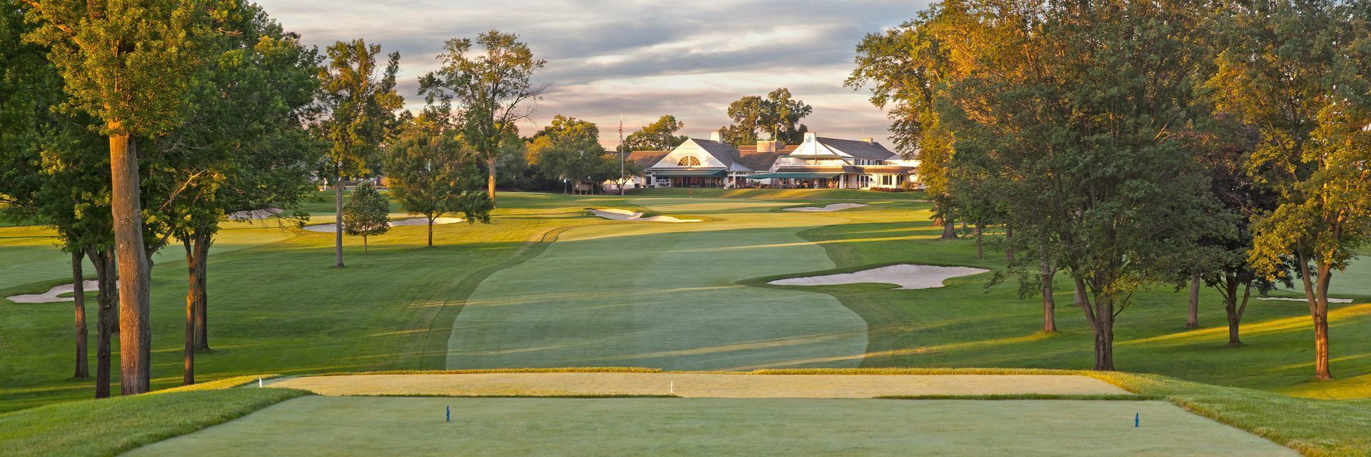 A golf course with trees and houses in the background