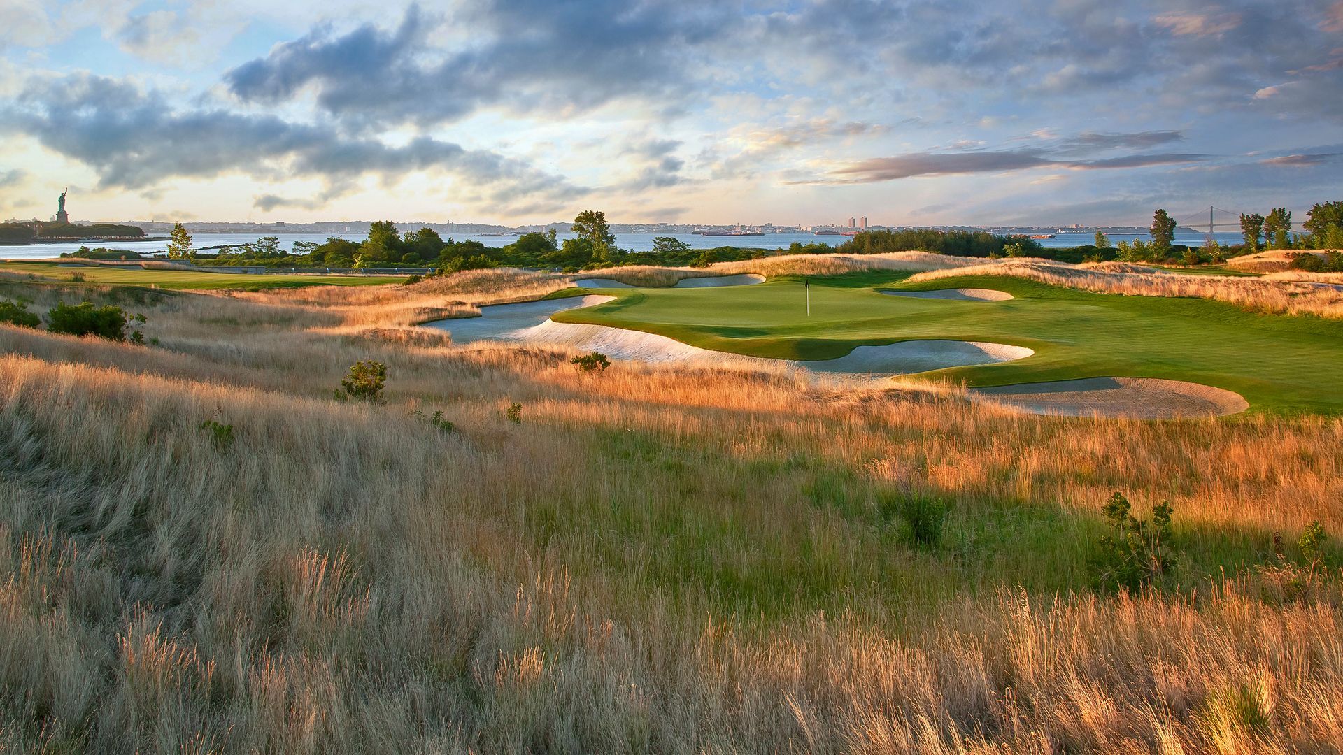 A golf course with the statue of liberty in the background