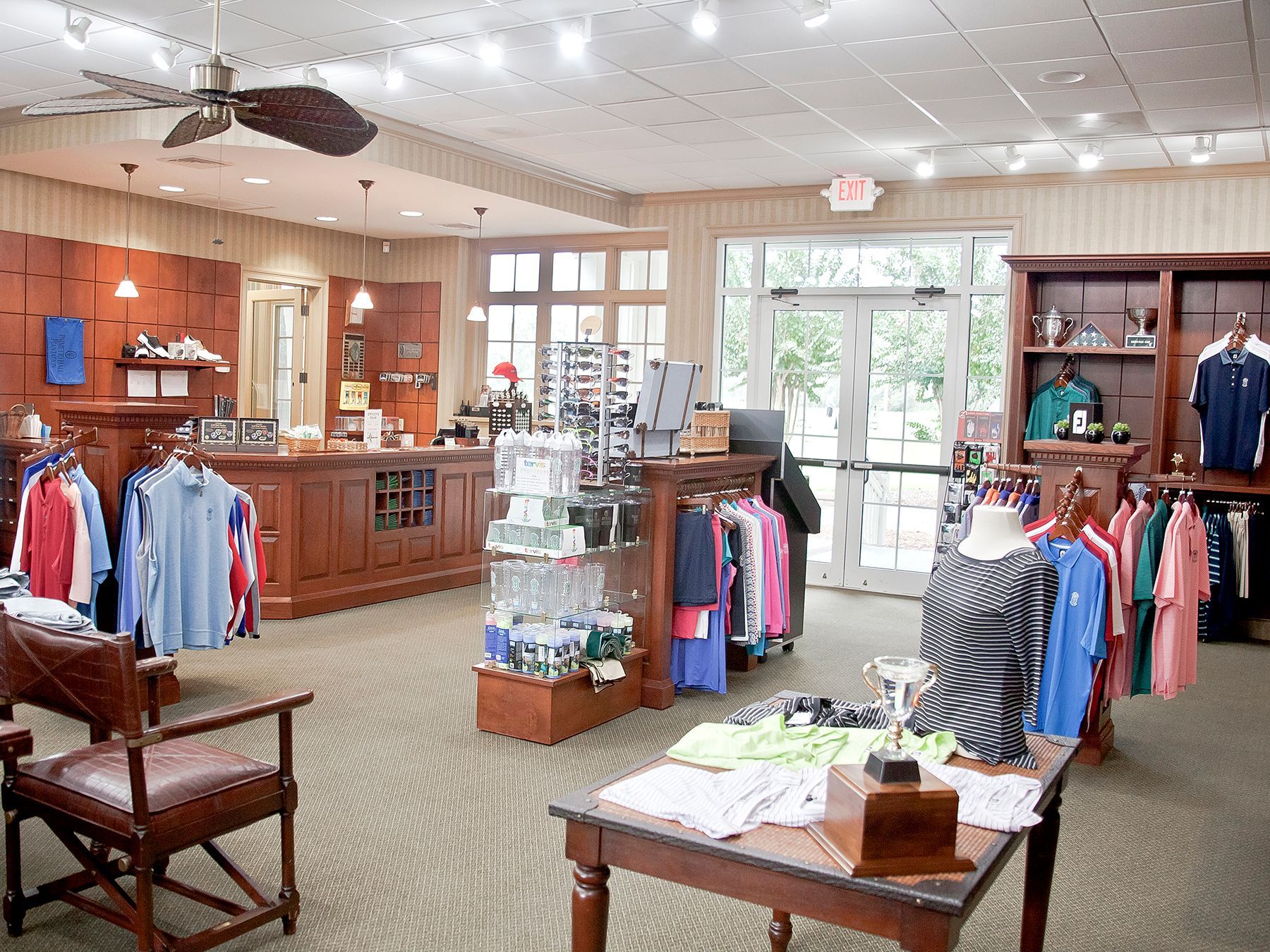 A store filled with lots of clothes and a ceiling fan.