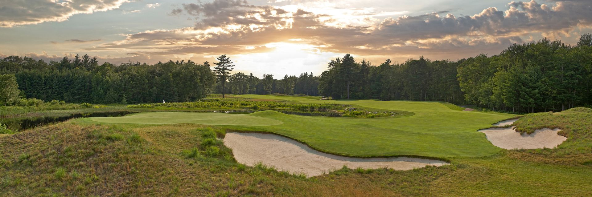 A golf course with a sunset in the background