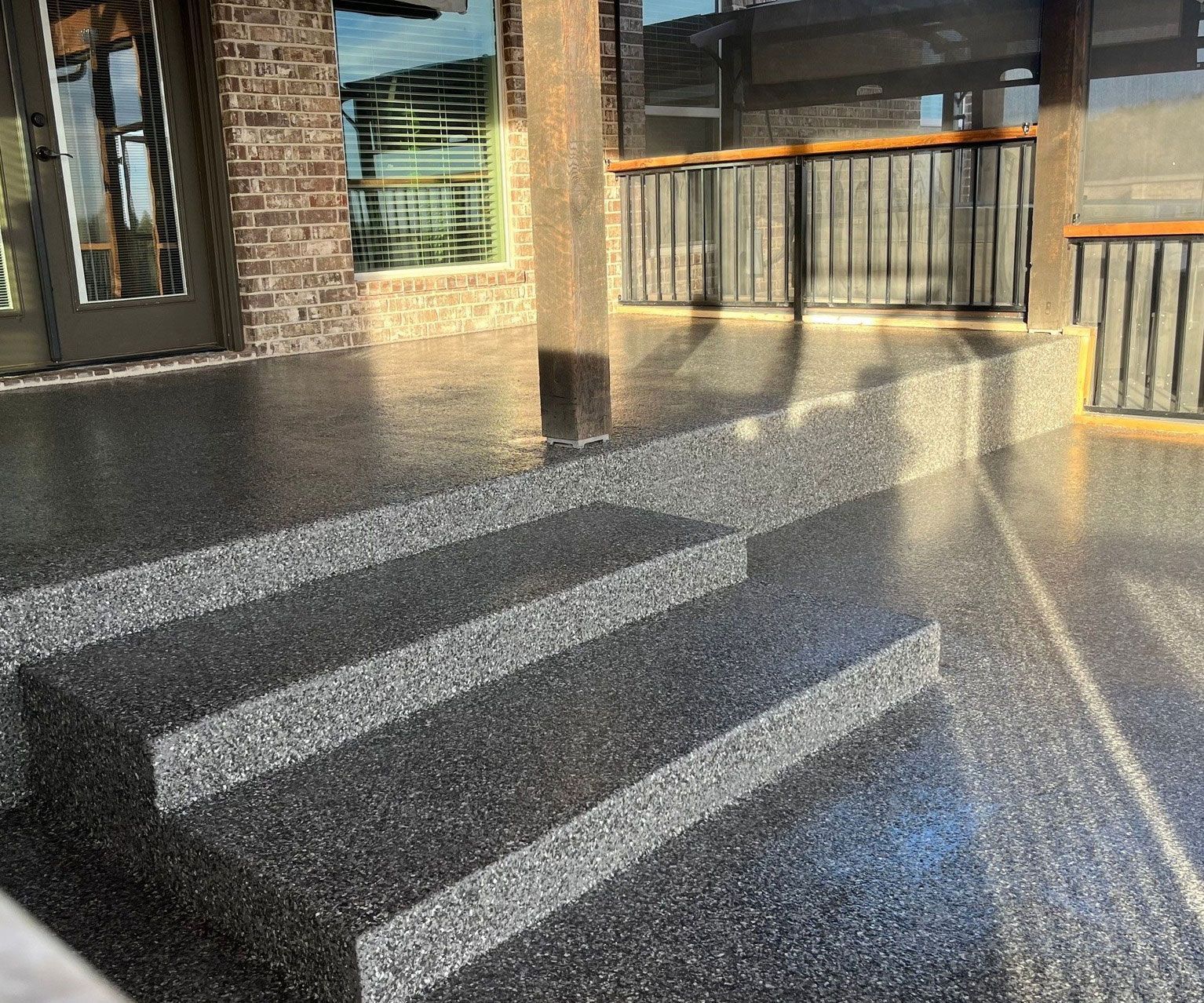 beautiful house patio with concrete floor coating and black wooden gate