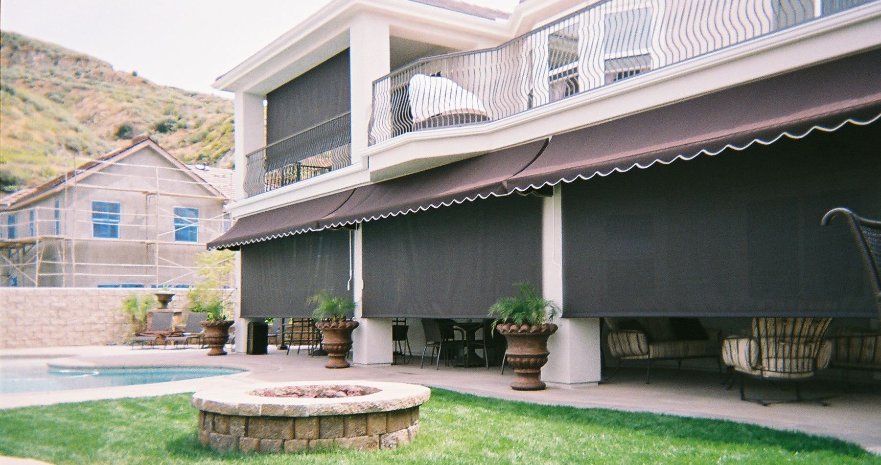 A house with a swimming pool and a fire pit in front of it