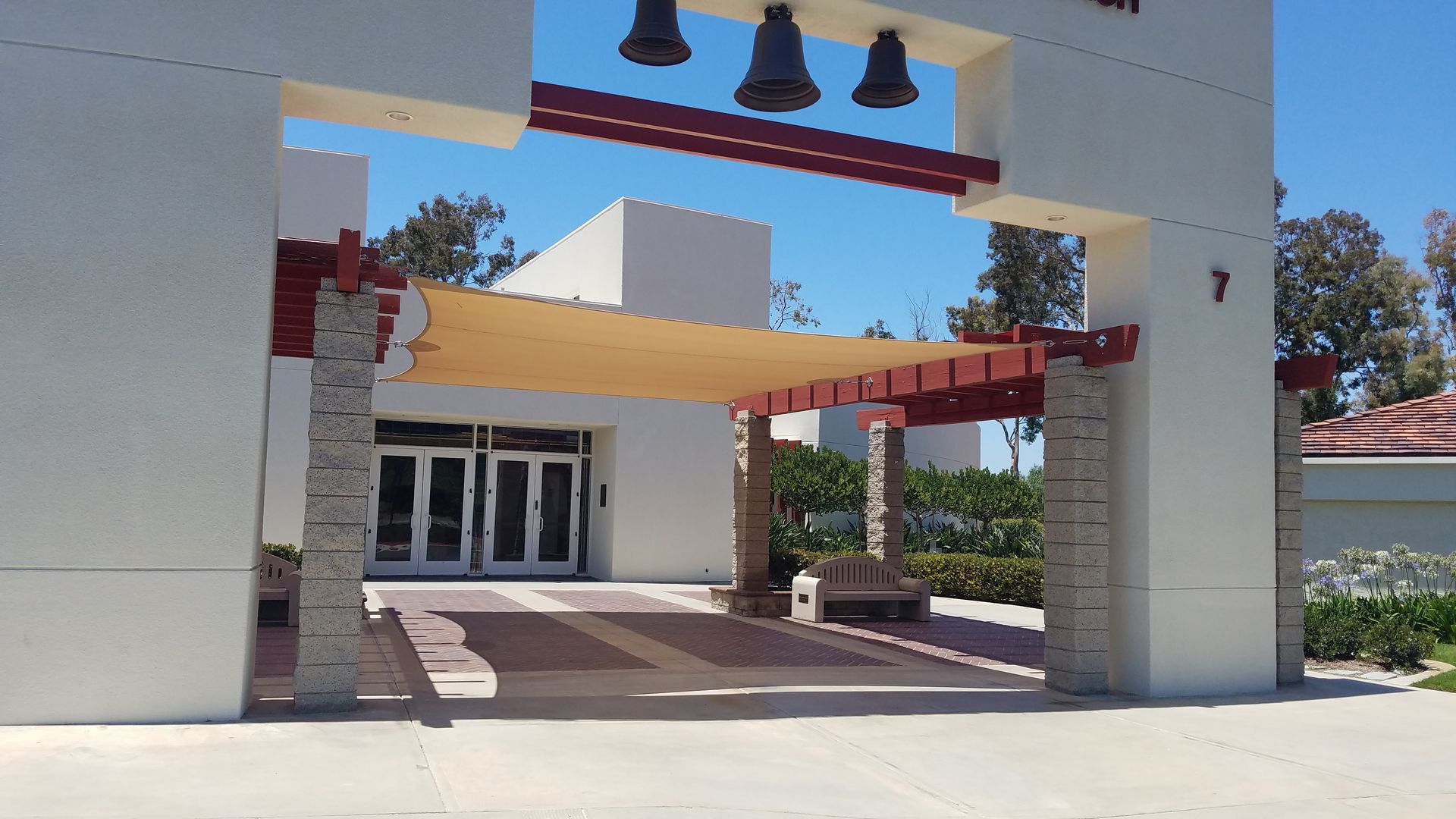 A white building with three bells on top of it