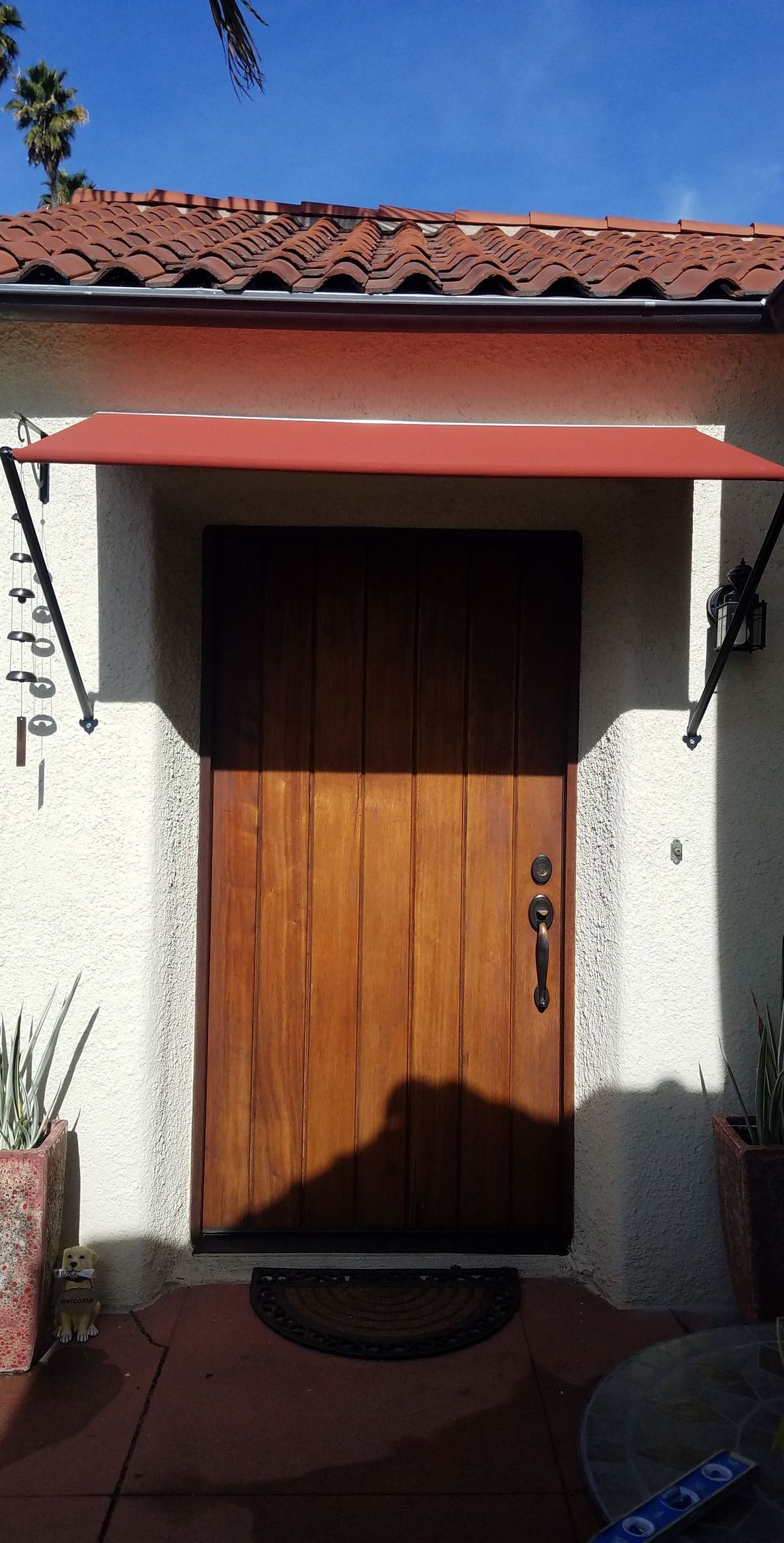 A wooden door with a red awning over it