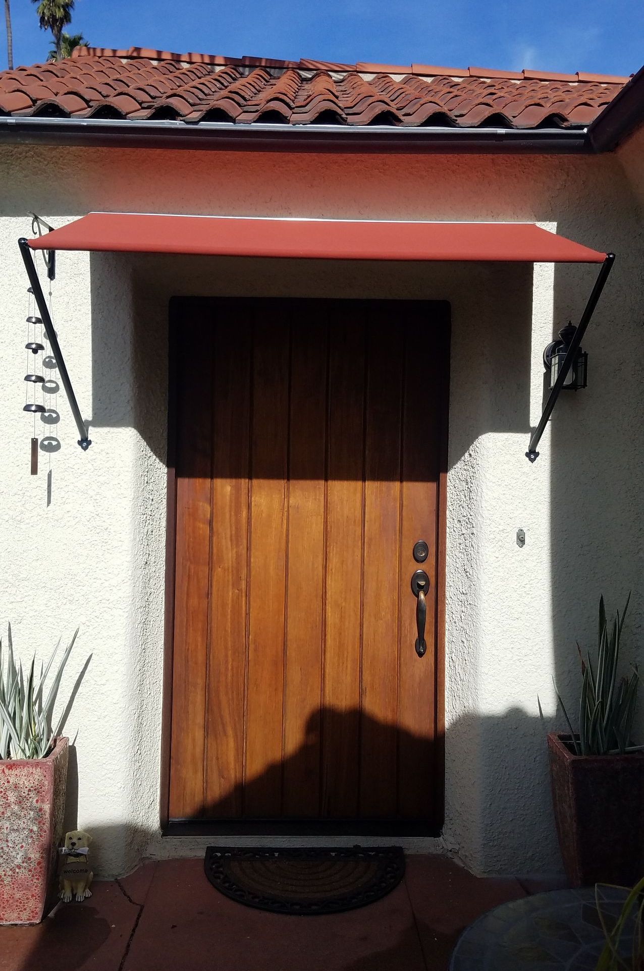 A wooden door with a red awning over it