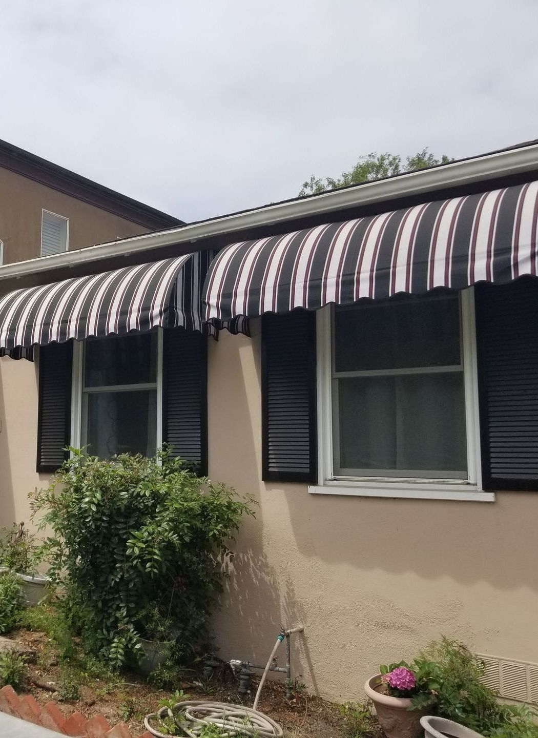 A house with a black and white striped awning over the windows.