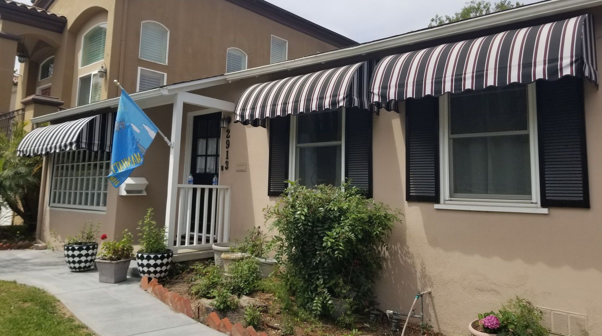 A house with a black and white awning on the front of it