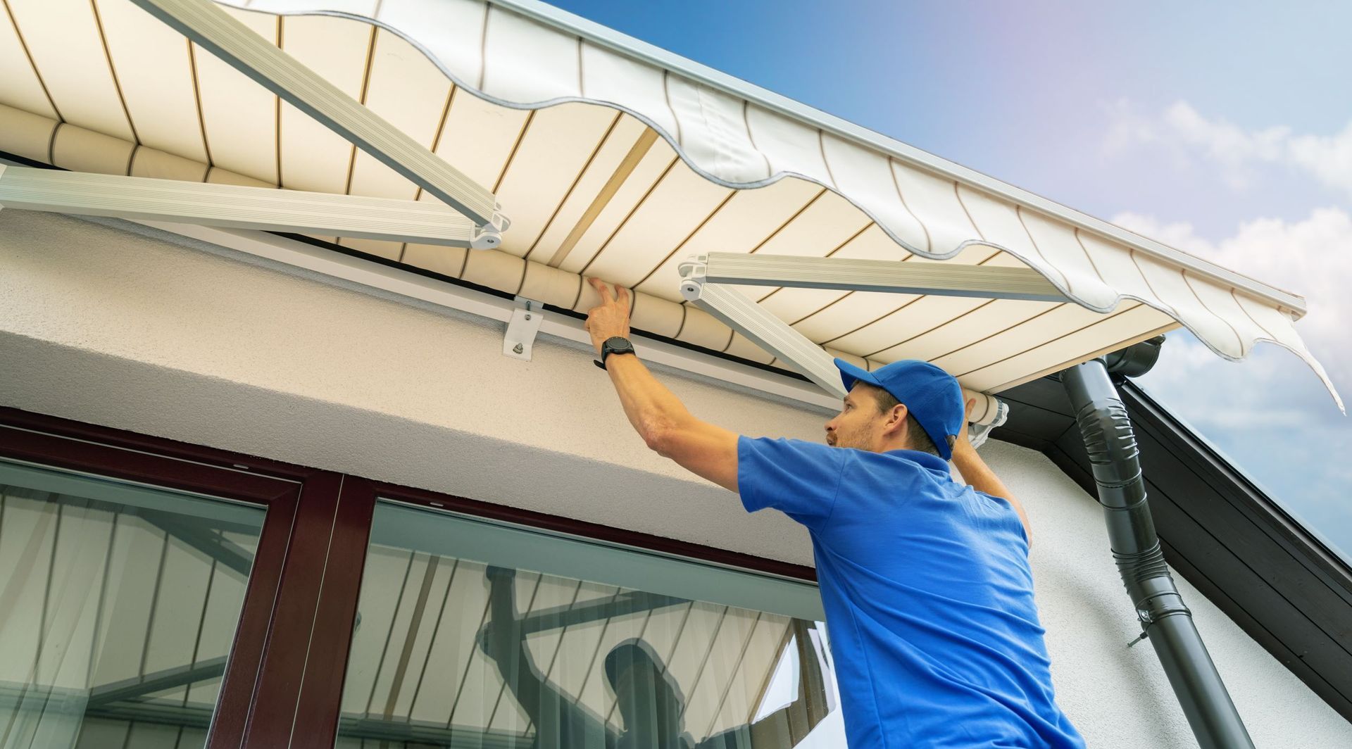 A man is installing an awning on the roof of a building.