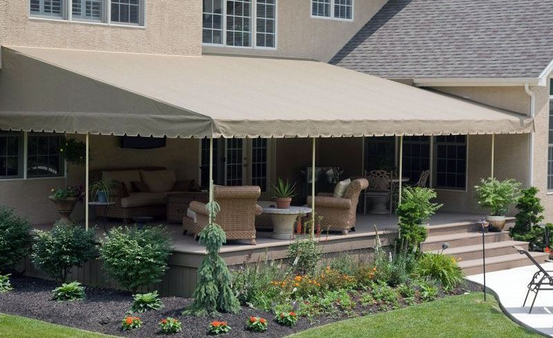 A patio with a canopy over it and a couch and chairs on it.