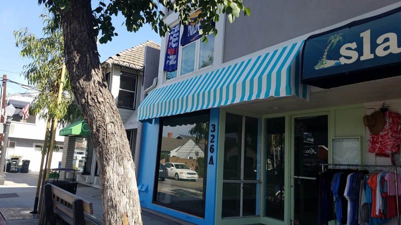 A store front with a blue awning that says lsla