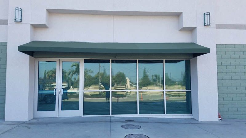 A white building with a green awning over the door