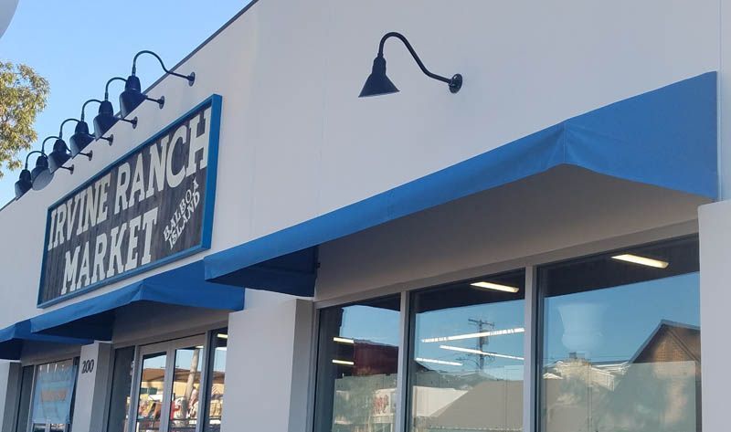 A white building with a blue awning that says ranch market