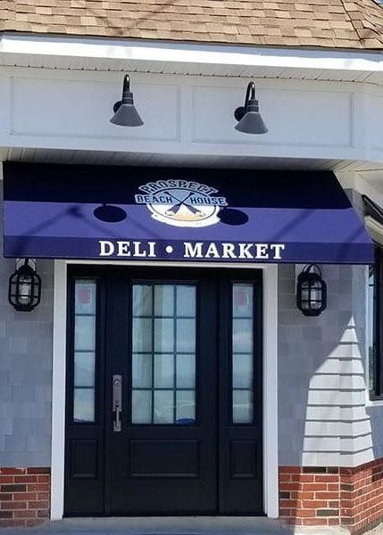 A deli market with a purple awning over the door