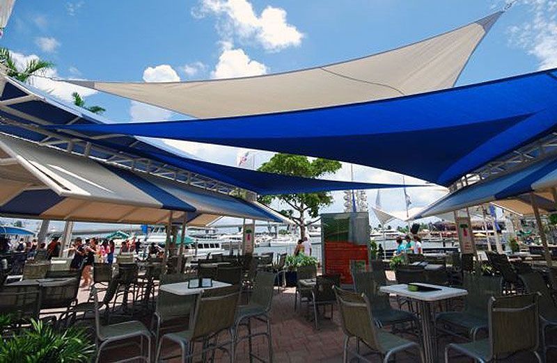 A restaurant with tables and chairs under blue and white umbrellas