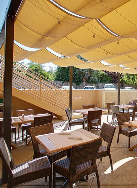 A restaurant with tables and chairs under umbrellas