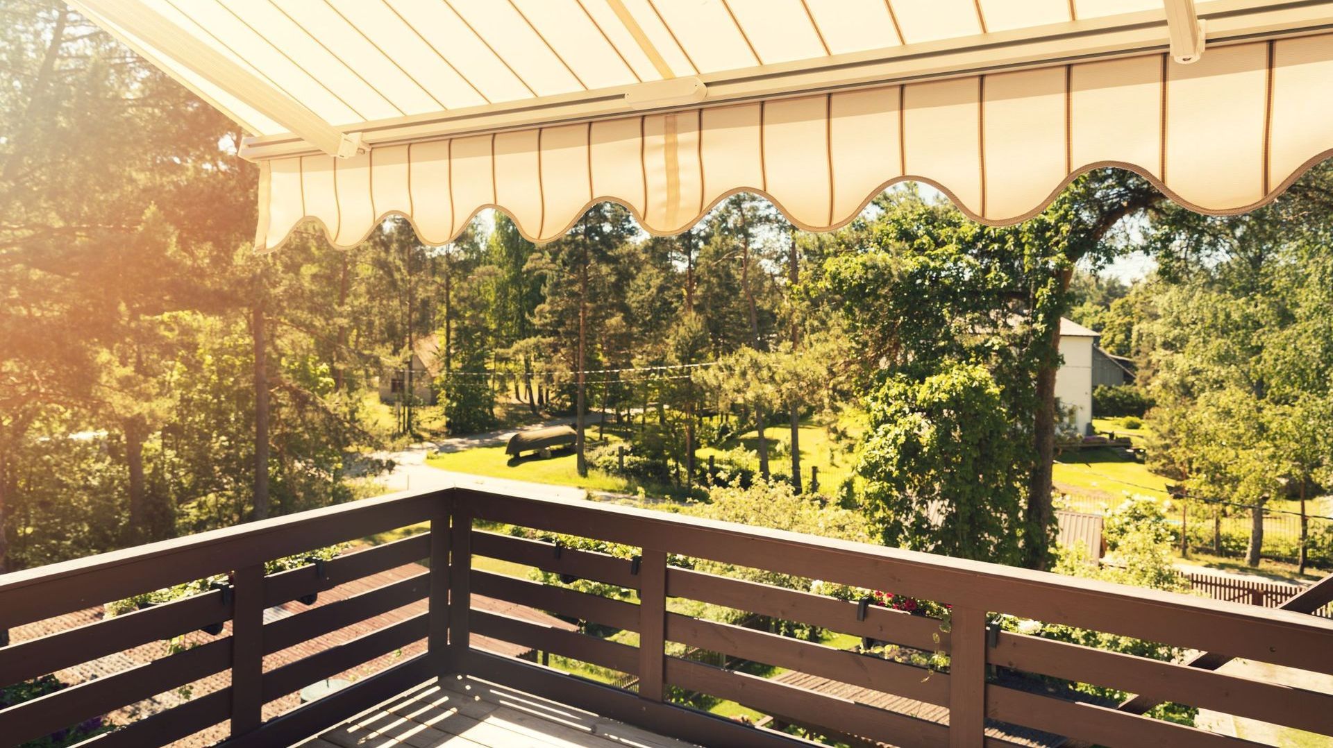 A balcony with a wooden railing and an awning over it.