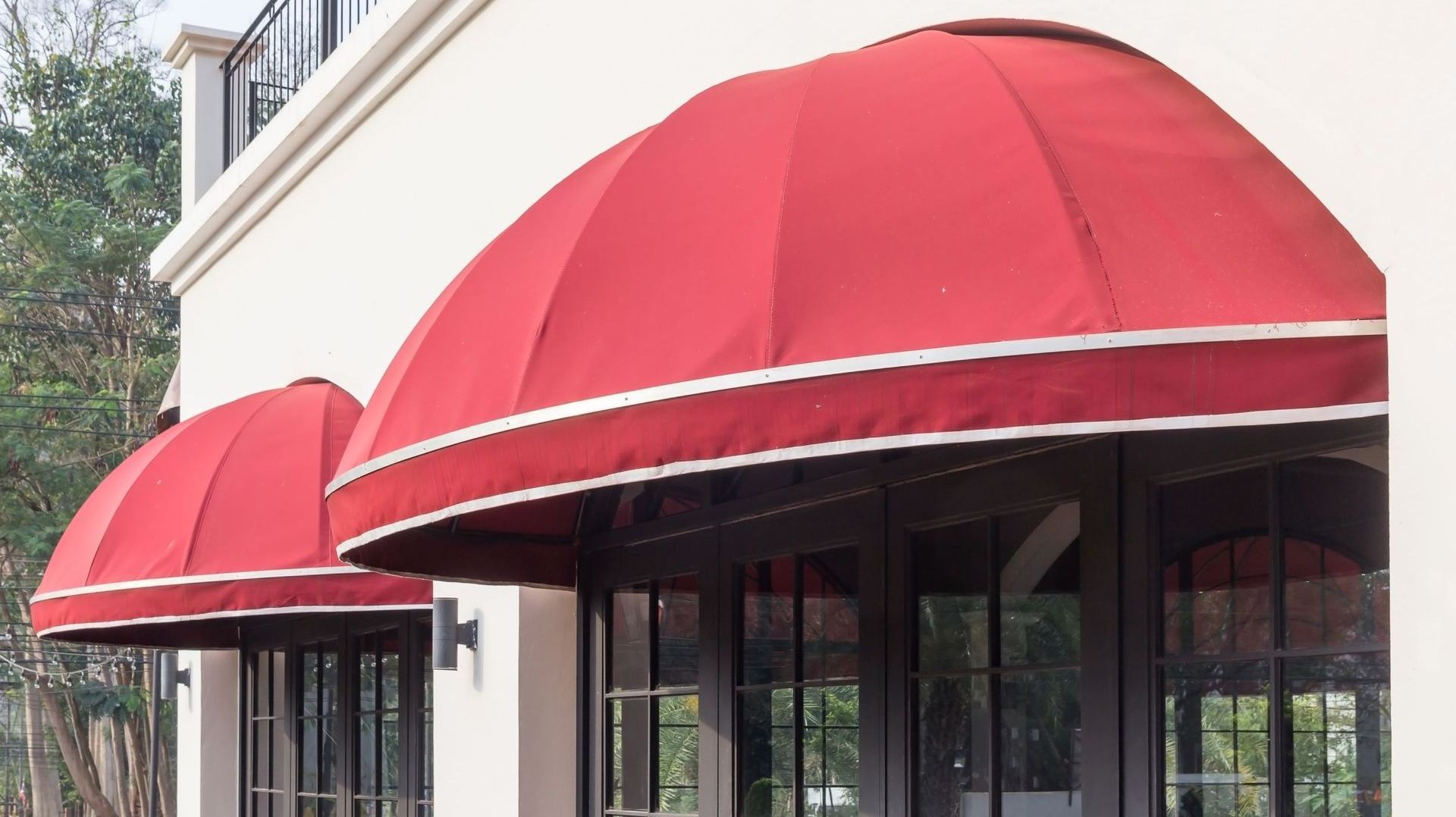 A white building with red awnings on the windows