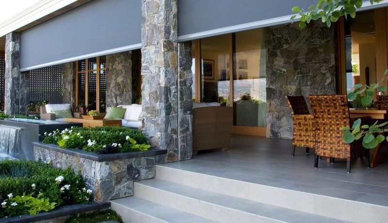 A patio with a table and chairs and a waterfall in the background.