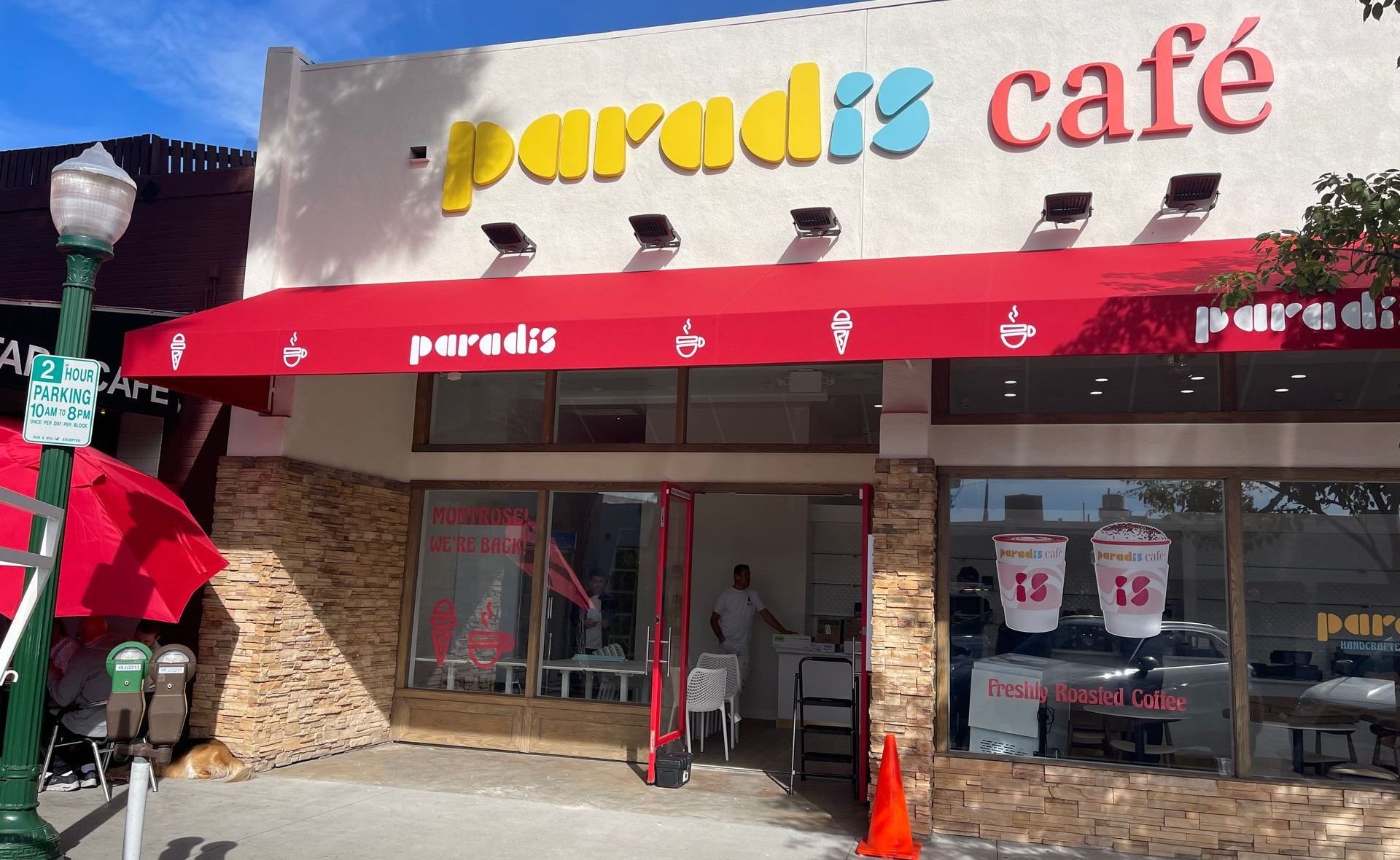 The paradis cafe has a red awning over the entrance