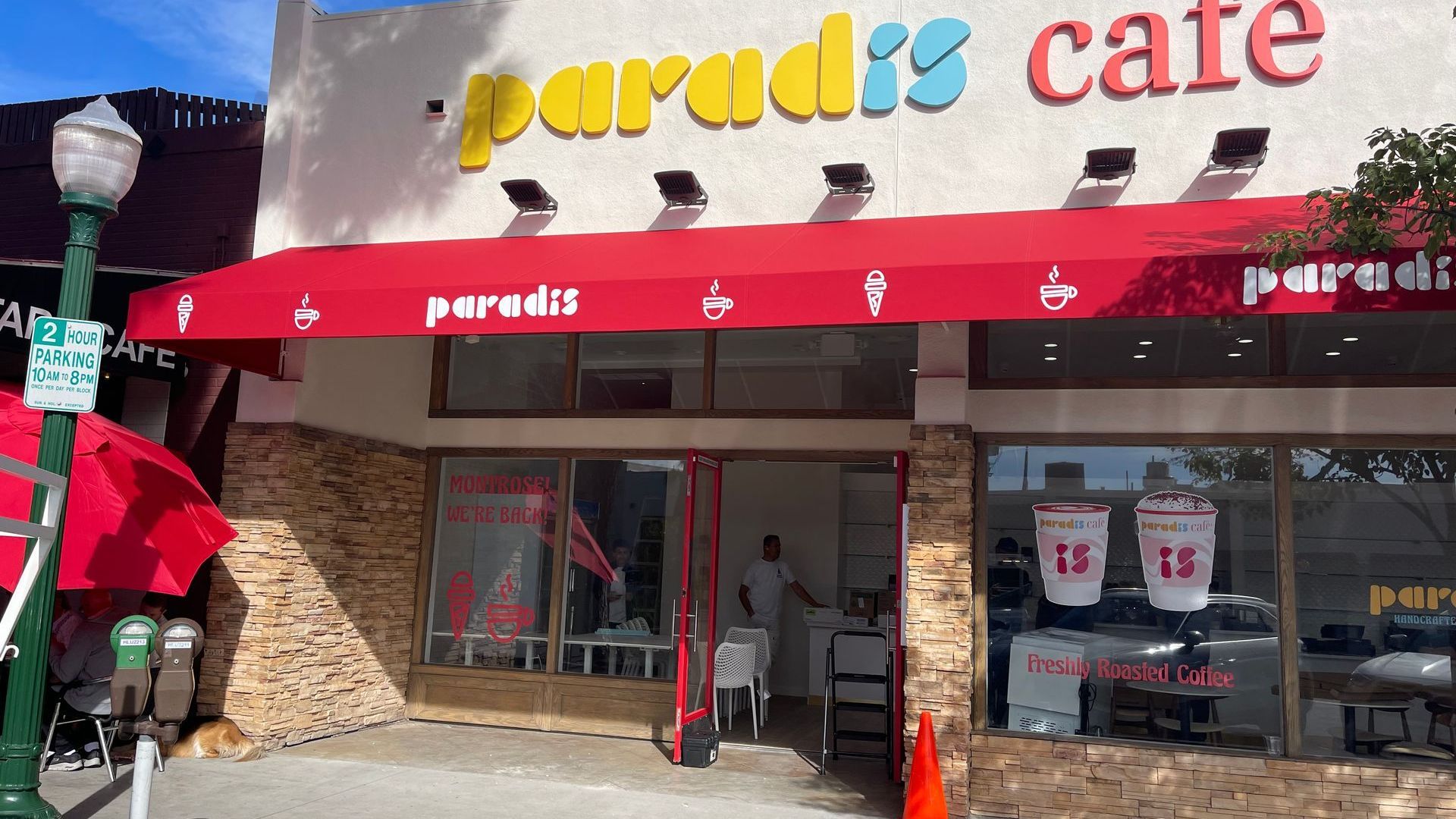 The paradis cafe has a red awning on the front of it.