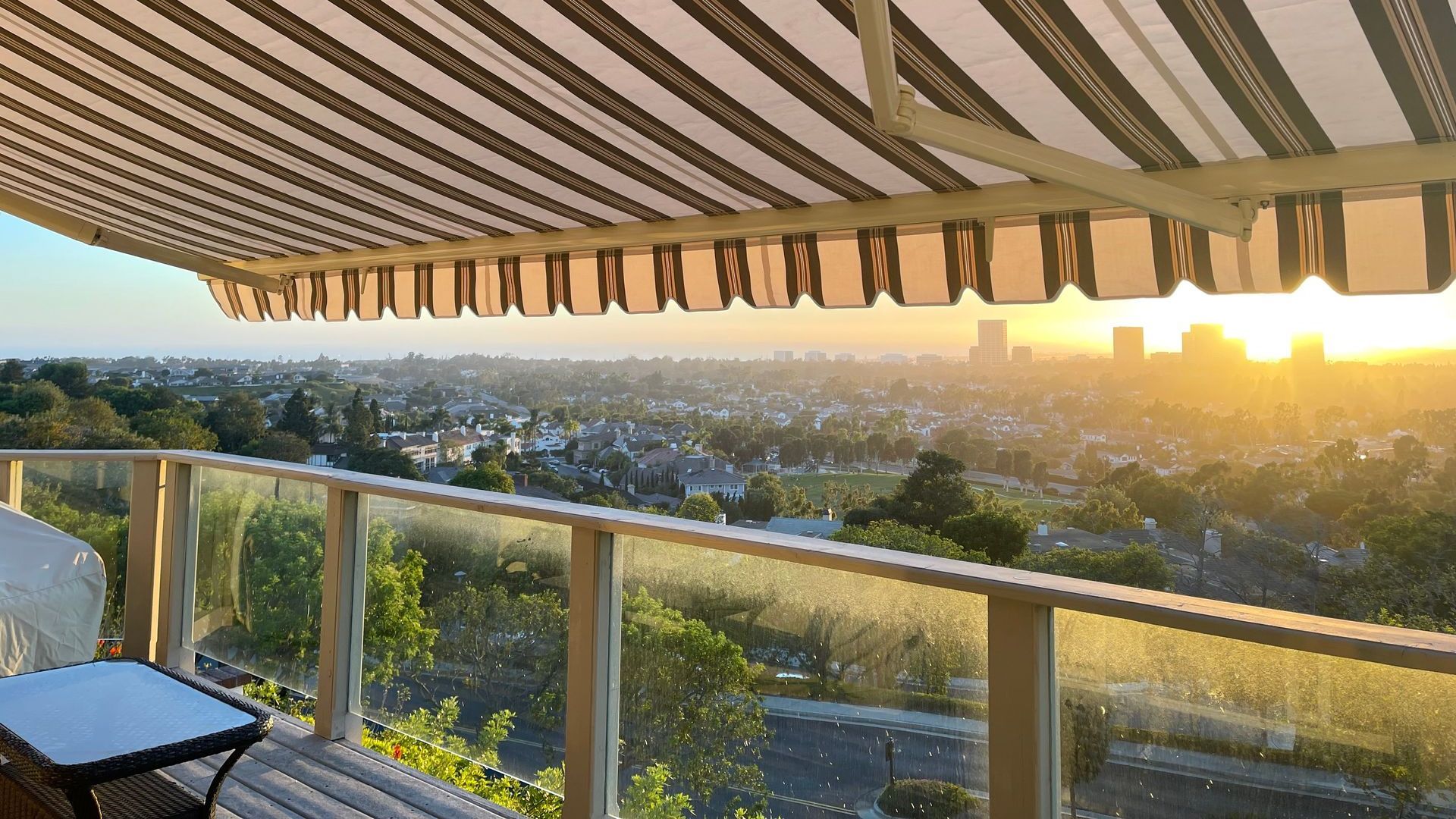 A balcony with a view of a city at sunset