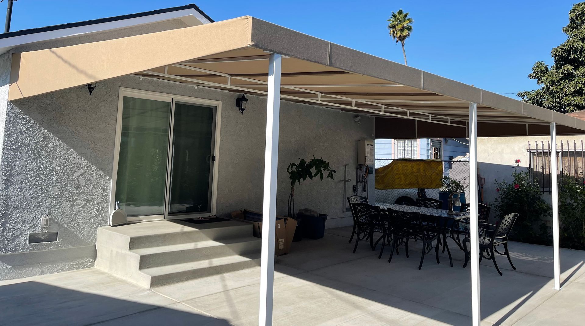 A patio with a table and chairs under a canopy.