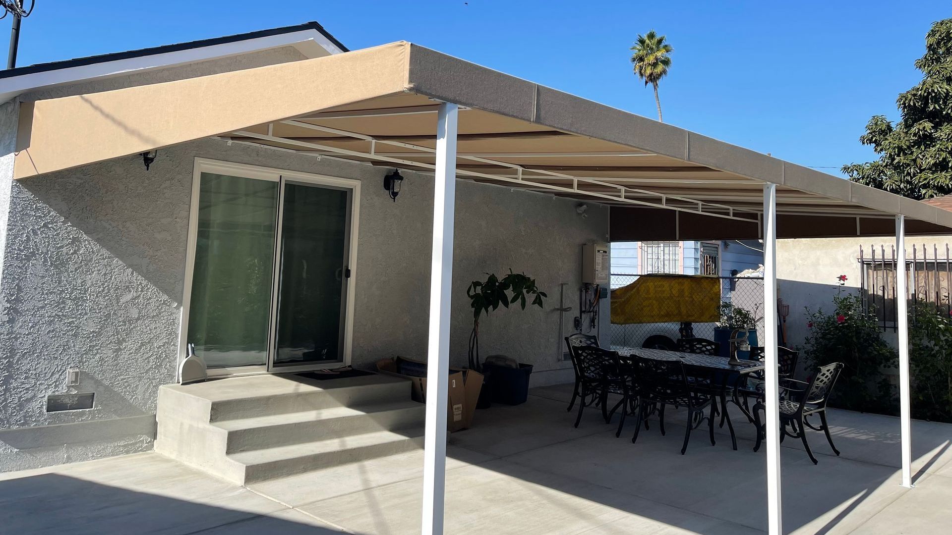 A patio with a table and chairs under a canopy