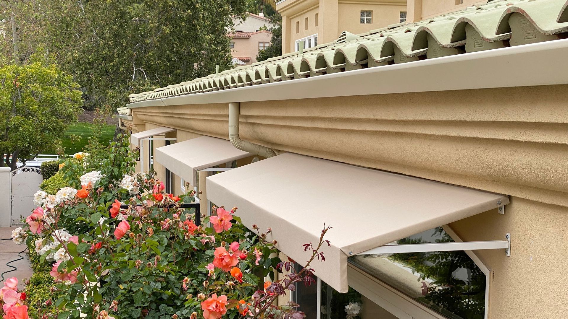 A white awning is hanging from the side of a building.