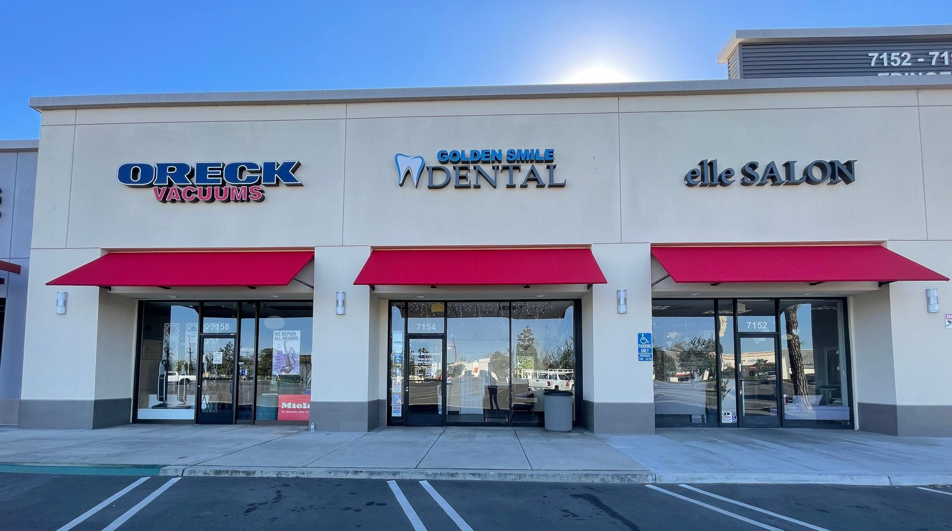 The outside of a dental office with red awnings