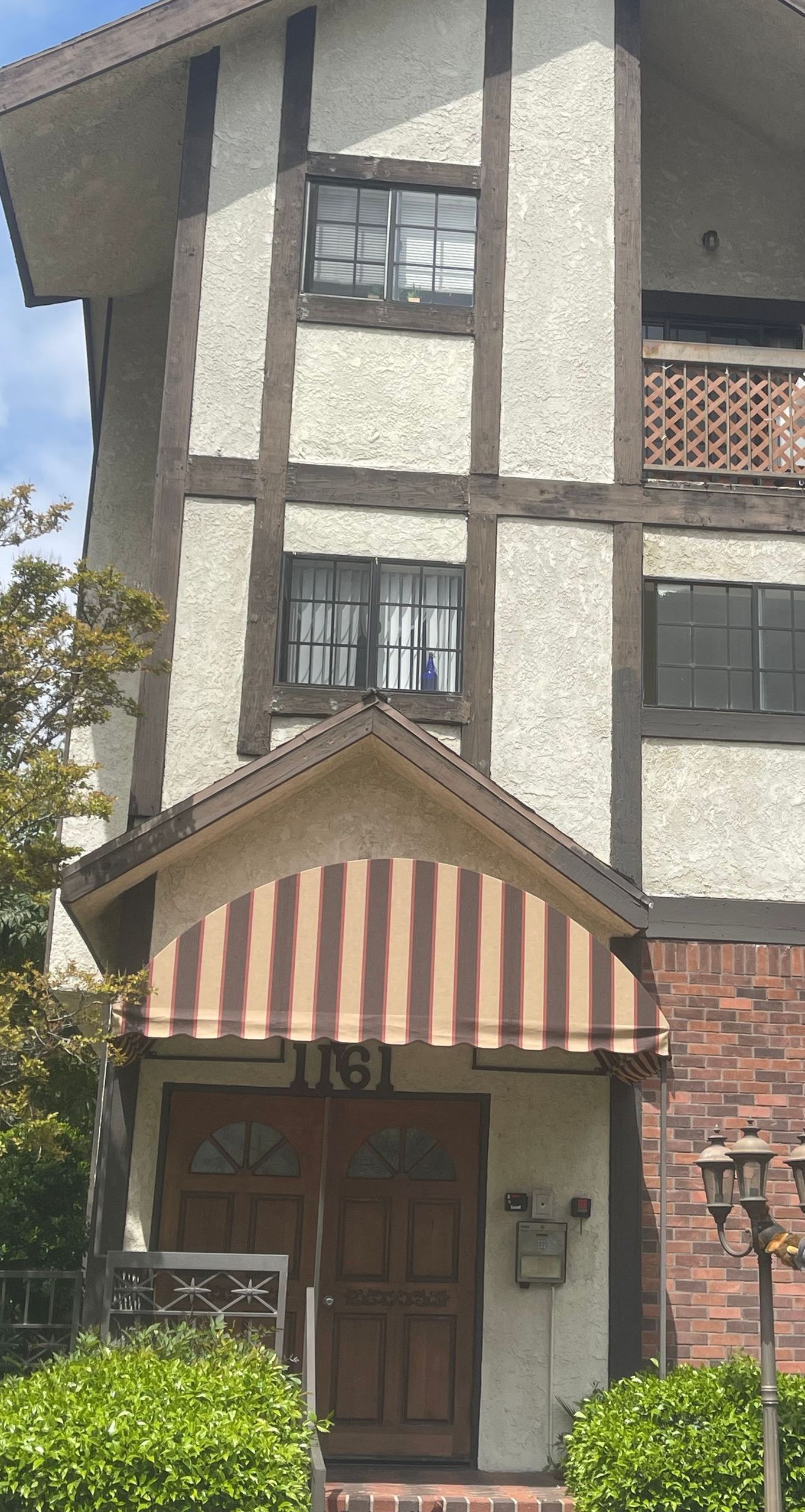 A large house with a striped awning on the front of it.