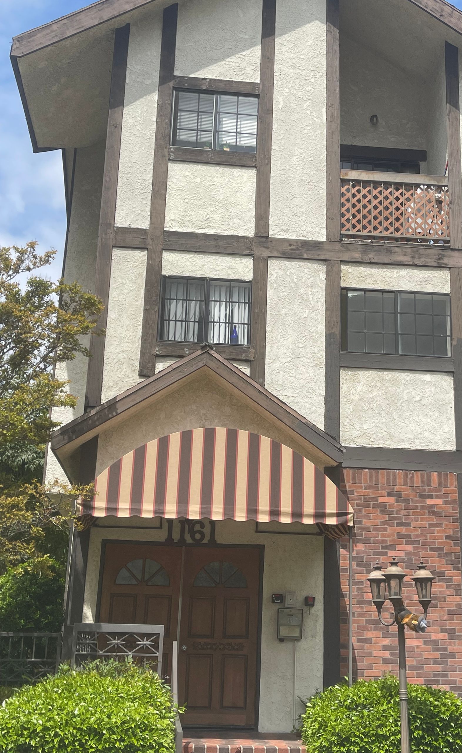 A large house with a striped awning over the front door.