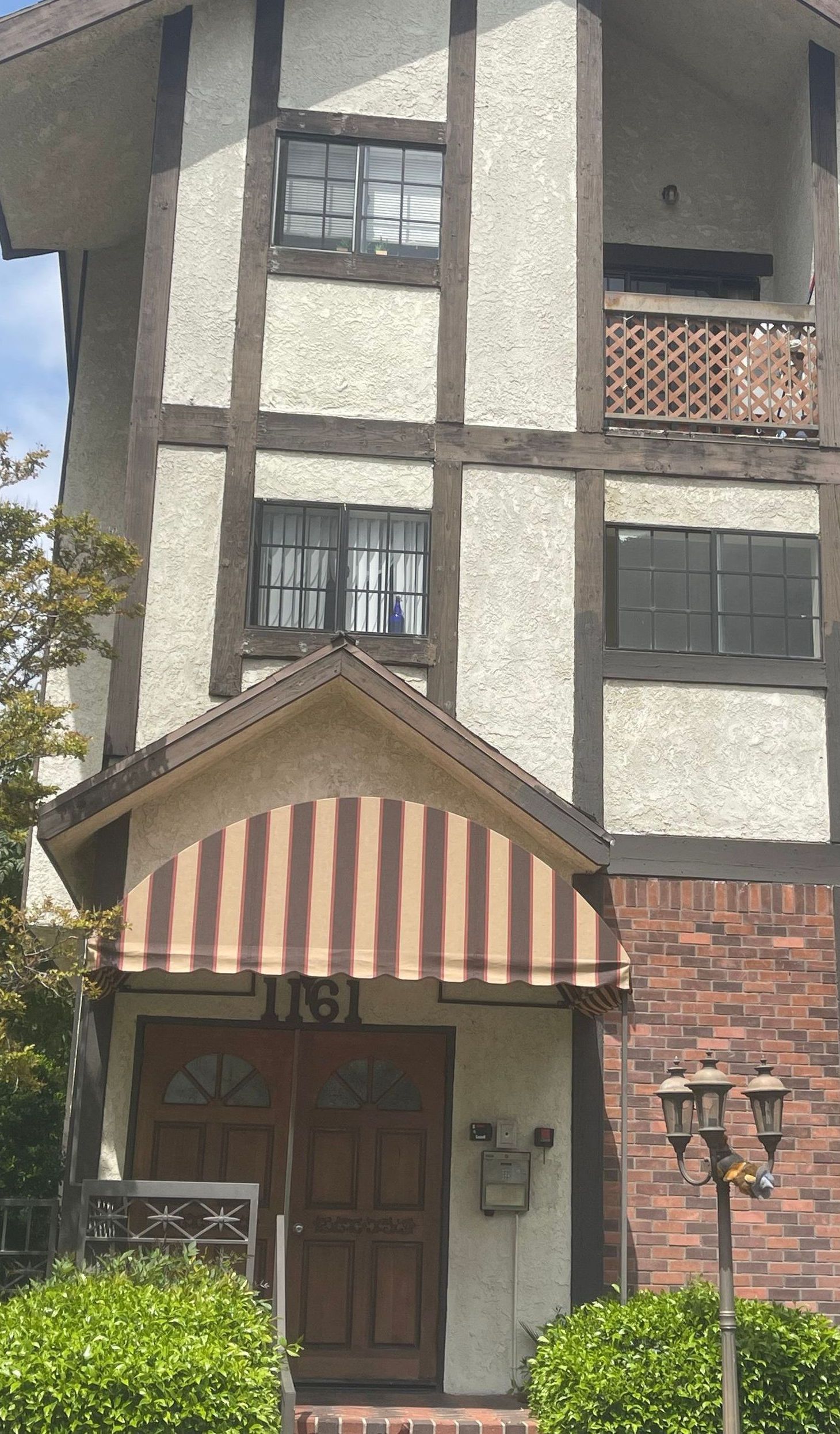 A large house with a striped awning over the front door