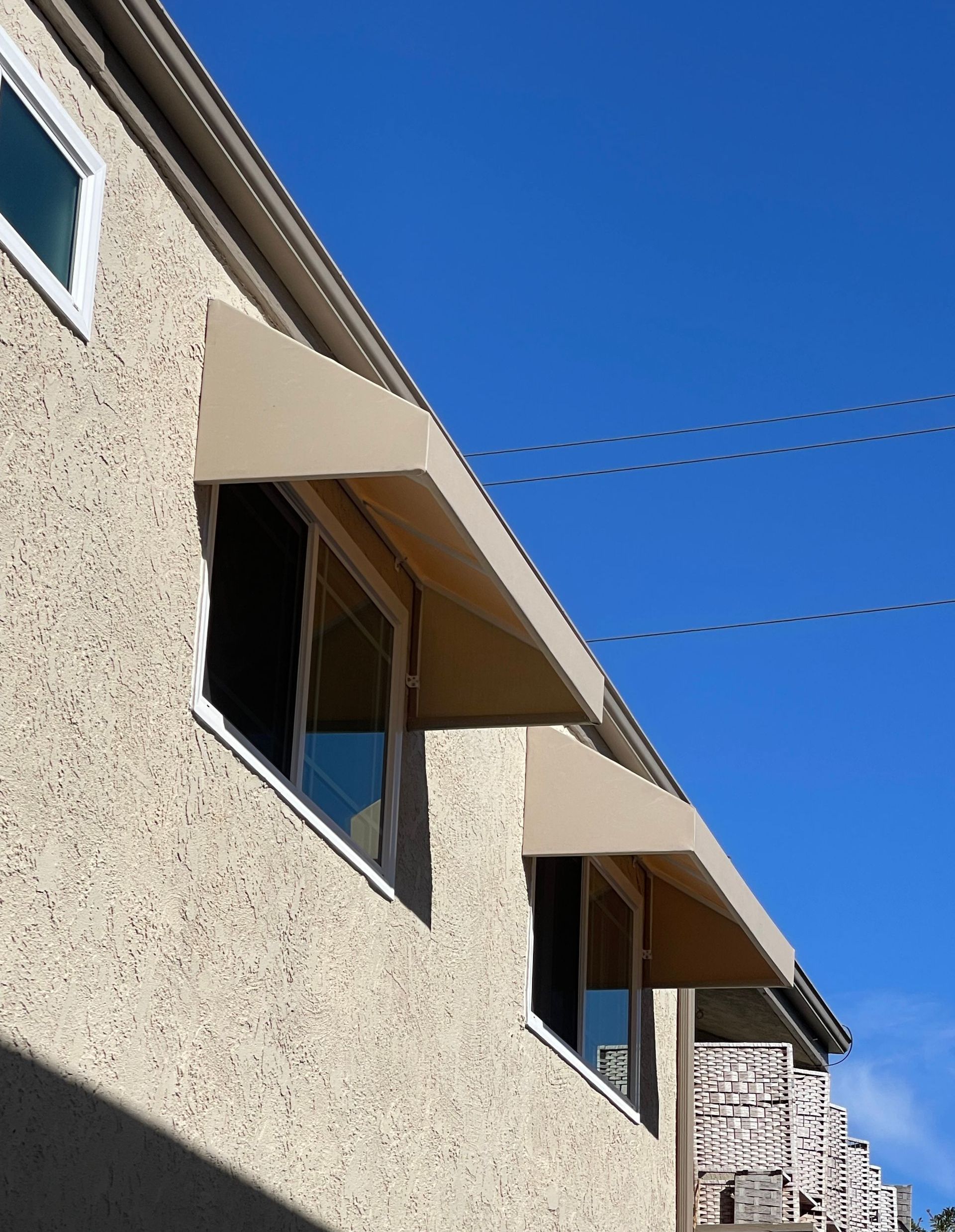 A building with a canopy over the windows on a sunny day