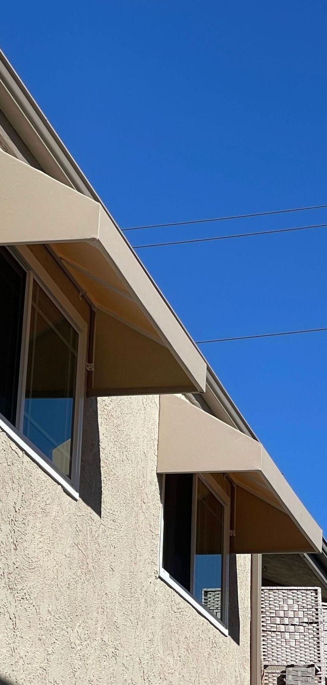 A building with a awning on the side of it and a blue sky in the background.