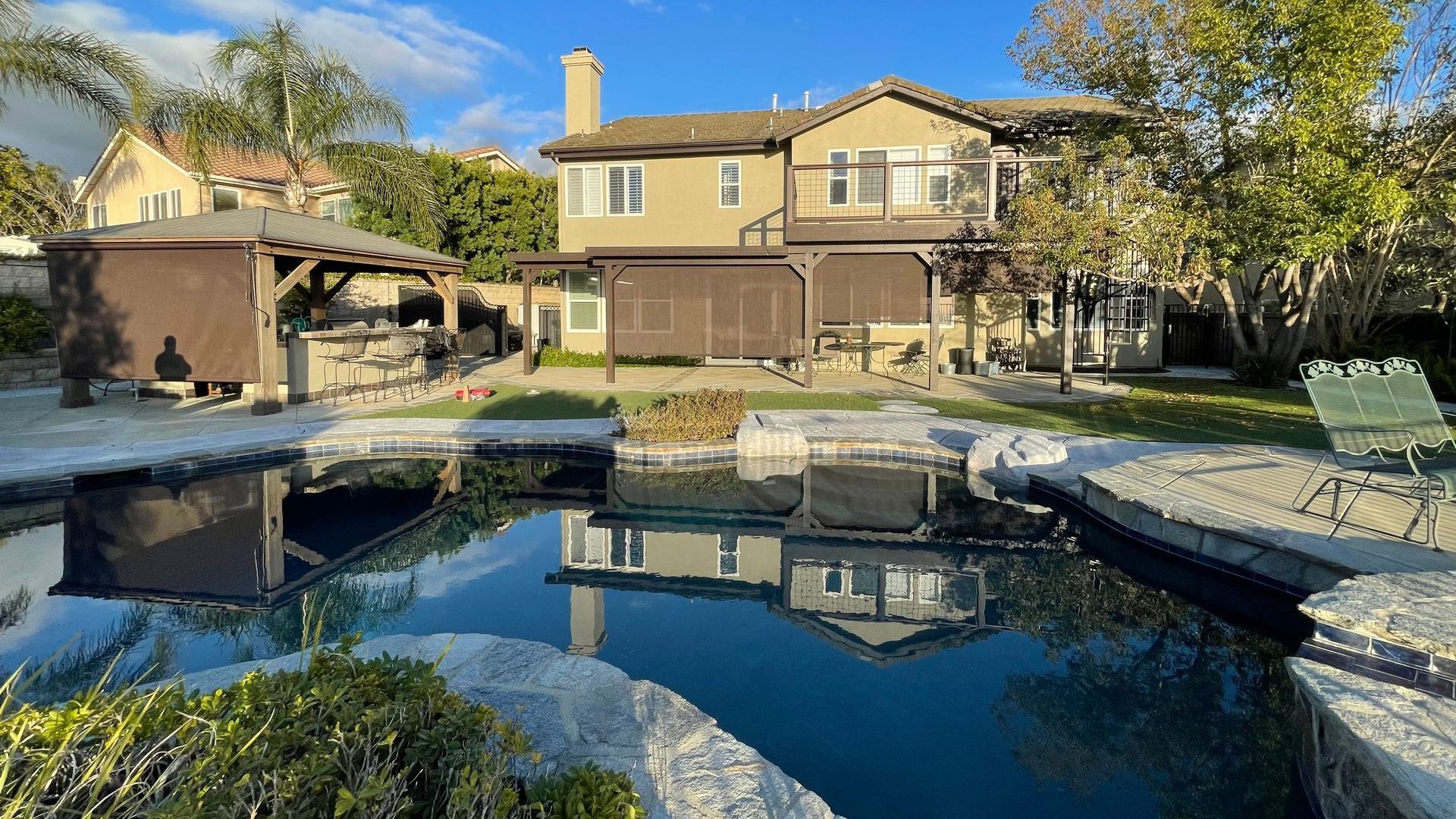 A large house with a swimming pool in front of it.