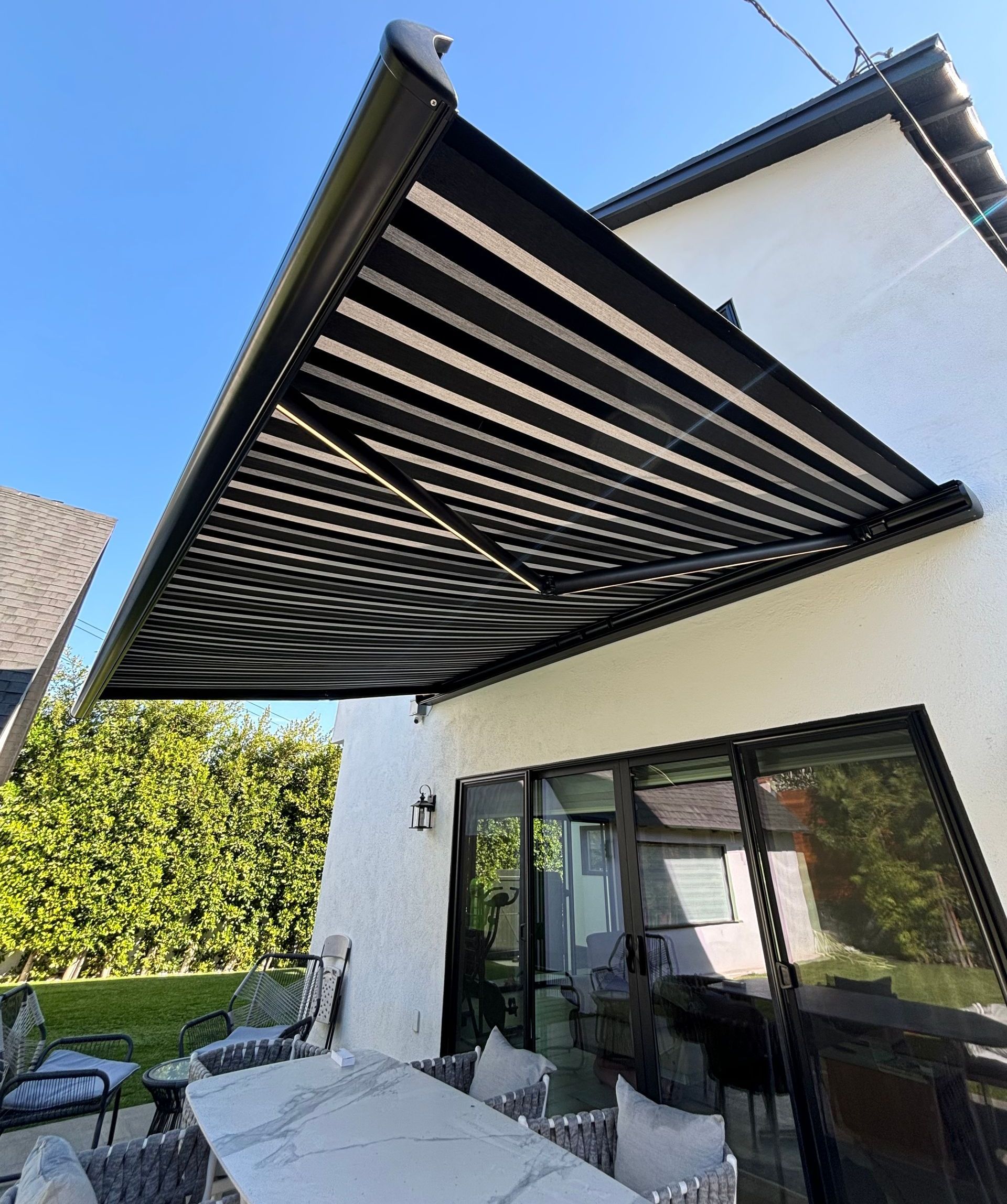 A patio with a table and chairs under an awning.