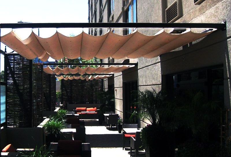 A patio with a canopy over it and a building in the background