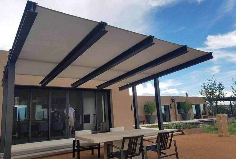 A patio with a table and chairs under a canopy.