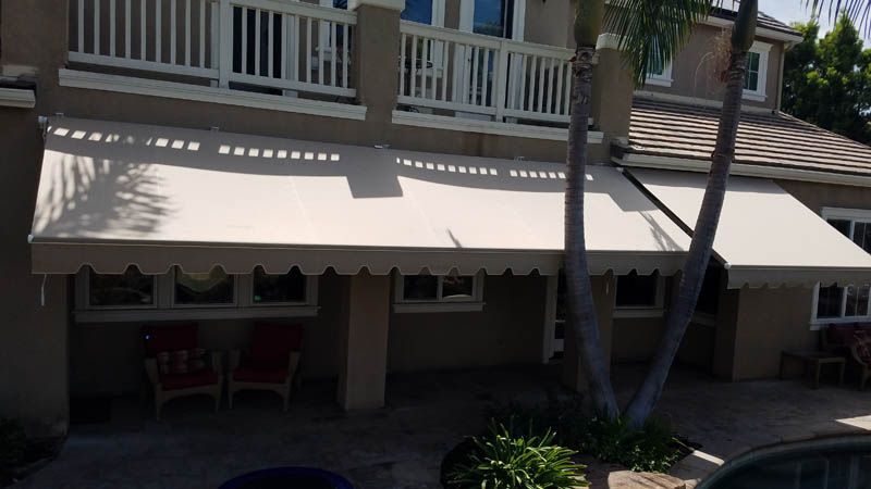 A gray building with red awnings on the windows