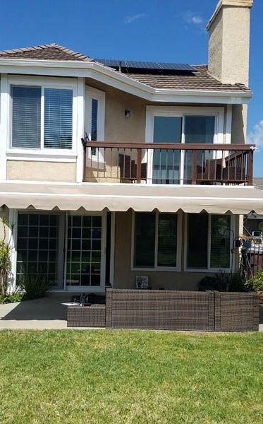 The back of a house with a balcony and awning.